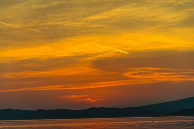 sahne turuncu kırmızı günbatımı gökyüzü göl Dağları üzerinde ufuk arka plan ile 