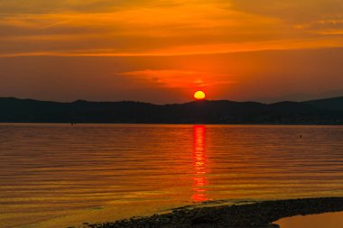turuncu kırmızı günbatımı gökyüzü göl su üstünde güneş ile  