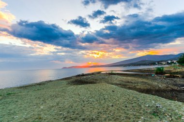 Günbatımında güneş ve renkli bulutlar gizleme ile boş deniz kıyısı