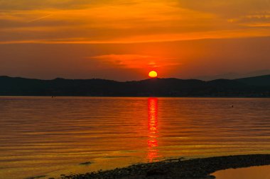 turuncu kırmızı günbatımı gökyüzü göl su üstünde güneş ile  