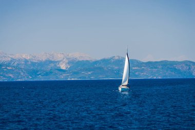 zemin üzerine mavi okyanus su ve dağlar Yelkenli tekne 