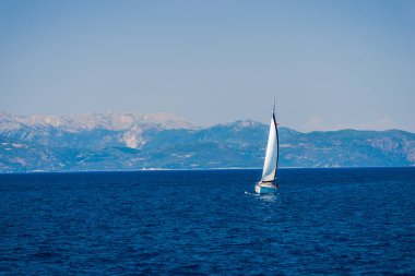 zemin üzerine mavi okyanus su ve dağlar Yelkenli tekne 