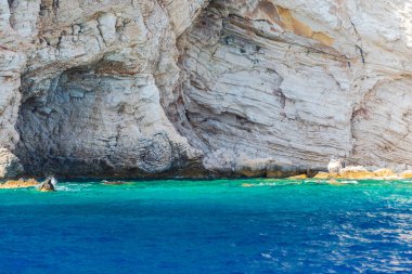 Sardunya, mavi deniz suyu ve beyaz dağ 