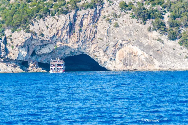 Kryssning Båt Blå Vatten Nära Grotta Klippiga Bergen — Stockfoto