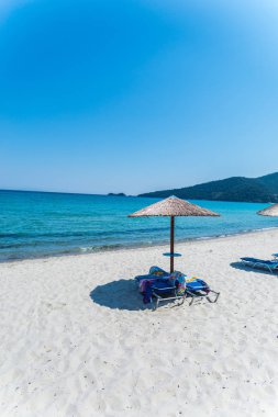 Yunanistan sahil plaj ve mavi deniz su, kumlu plajda şemsiye 