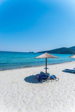 Yunanistan sahil plaj ve mavi deniz su, kumlu plajda şemsiye 