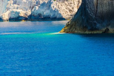 Büyük uçurum ve mavi su yüzeyi ile deniz manzarası.