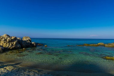 Deniz kıyısı mavi gökyüzü arka plan karşı taşlarla