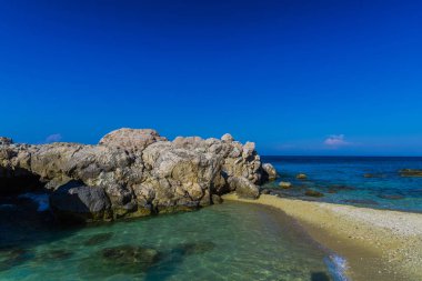 Deniz kıyısı mavi gökyüzü arka plan karşı taşlarla