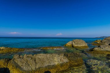 Turkuaz su ve büyük taşlar ile deniz kıyısı