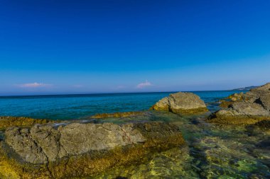 Turkuaz su ve büyük taşlar ile deniz kıyısı