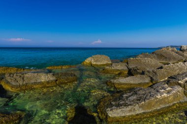 Turkuaz su ve büyük taşlar ile deniz kıyısı