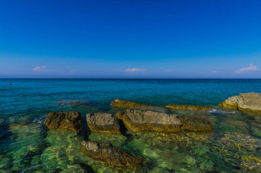Turkuaz su ve büyük taşlar ile deniz kıyısı