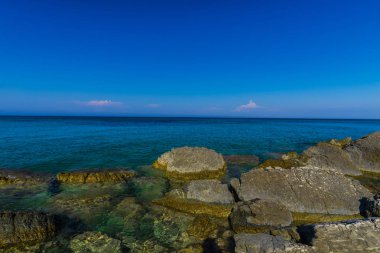 Turkuaz su ve büyük taşlar ile deniz kıyısı