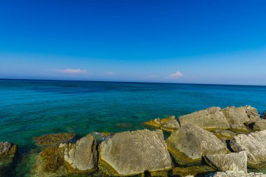 Turkuaz su ve büyük taşlar ile deniz kıyısı