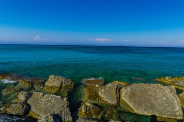 Turkuaz su ve büyük taşlar ile deniz kıyısı