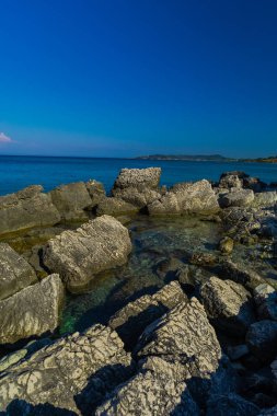 Turkuaz su ve büyük taşlar ile deniz kıyısı