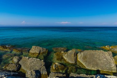 Turkuaz su ve büyük taşlar ile deniz kıyısı