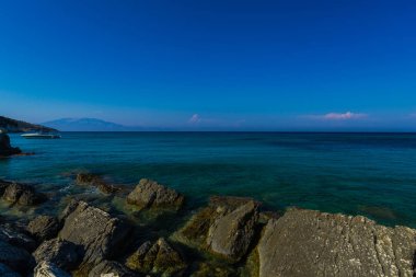Turkuaz su ve büyük taşlar ile deniz kıyısı