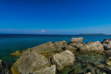 Turkuaz su ve büyük taşlar ile deniz kıyısı