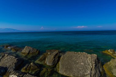 Turkuaz su ve büyük taşlar ile deniz kıyısı