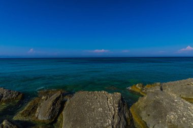 Turkuaz su ve büyük taşlar ile deniz kıyısı