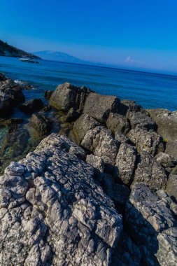 Turkuaz su ve büyük taşlar ile deniz kıyısı