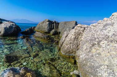 Turkuaz su ve büyük taşlar ile deniz kıyısı