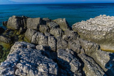 Turkuaz su ve büyük taşlar ile deniz kıyısı