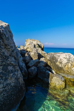 Turkuaz su ve büyük taşlar ile deniz kıyısı
