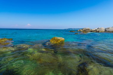 Turkuaz su ve büyük taşlar ile deniz kıyısı
