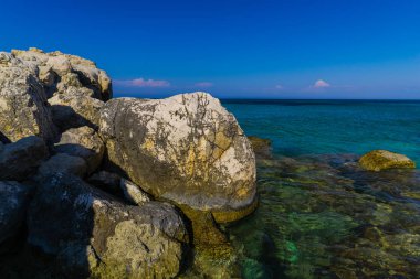 Turkuaz su ve büyük taşlar ile deniz kıyısı