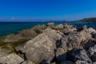 Turkuaz su ve büyük taşlar ile deniz kıyısı