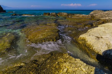 Turkuaz su ve büyük taşlar ile deniz kıyısı