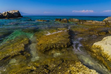 Turkuaz su ve büyük taşlar ile deniz kıyısı