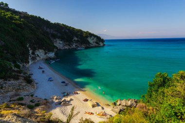 Sabahın erken saatlerinde, Yunanistan sahil güneşlenme turist.