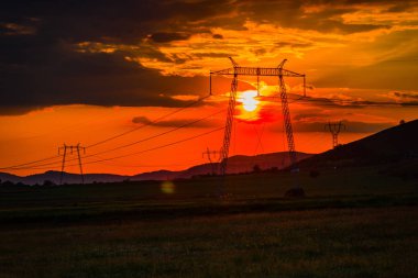 parlak kırmızı günbatımı gökyüzü ve elektrik direkleri