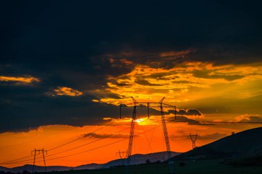 parlak kırmızı günbatımı gökyüzü ve elektrik direkleri