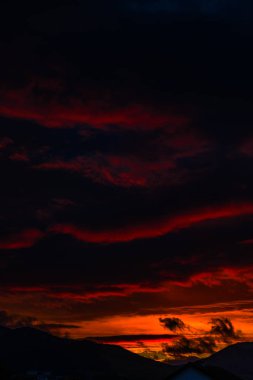 görkemli turuncu günbatımı gökyüzü bulutlar ve tepeler ile 