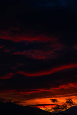 görkemli turuncu günbatımı gökyüzü bulutlar ve tepeler ile 