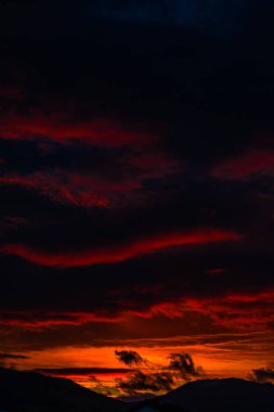 görkemli turuncu günbatımı gökyüzü bulutlar ve tepeler ile 