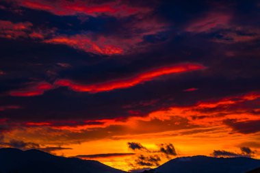 görkemli turuncu günbatımı gökyüzü bulutlar ve tepeler ile 