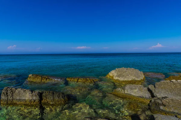 Turkuaz su ve büyük taşlar ile deniz kıyısı