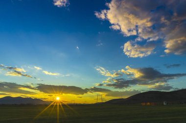 Bahar günbatımı güneş ve bulutlar gizleme ile alanında