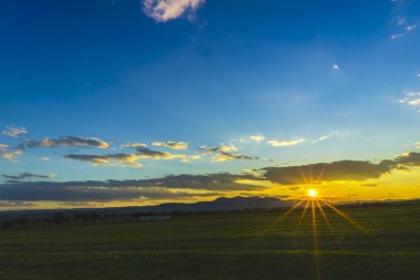 Bahar günbatımı güneş ve bulutlar gizleme ile alanında
