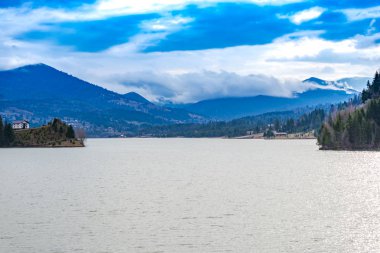Güneşli gündüz leri köknar ağaçları ve pürüzsüz gölle kaplı dağlar