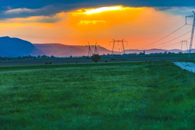 Elektrik direkleri ve gökyüzü arka plan ile Alan