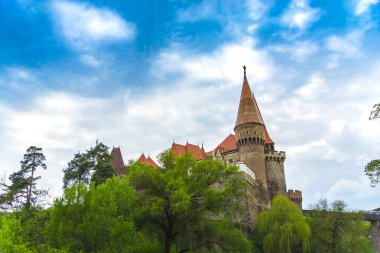 Ortaçağ Corvinesti Kalesi ve mavi gökyüzü bulutlu, Romanya 