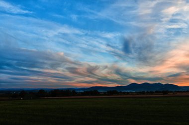bulutların üzerinde manzara çayır alan Hills ile mavi günbatımı gökyüzü