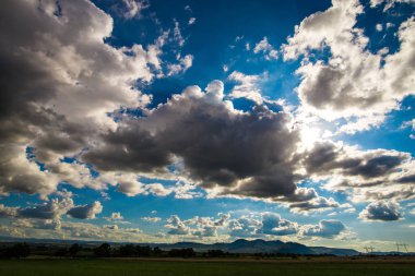 Mavi gökyüzü manzara çayır alanının üstündeki beyaz bulutlar ile 